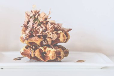 Belçika Liege waffle tepesinde durumda takoyaki sosu, Japon mayonez, Japon baharat ve palamut gevreği ile