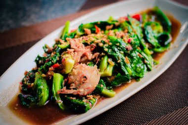 Tay tavada kızartılmış taze bebek kailan karides, sarımsak ve istiridye sosu ile.