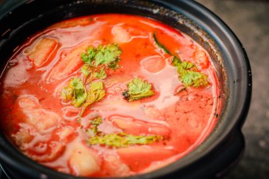 Tom Yum Thai stil sıcak ve ekşi çorba, levrek, kalamar ve karides 