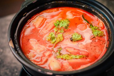 Tom Yum Thai stil sıcak ve ekşi çorba, levrek, kalamar ve karides 