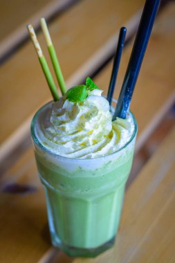 çırpılmış krem nane yaprakları çikolata sopa ile harmanlanmış matcha latte