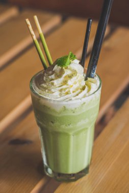 çırpılmış krem nane yaprakları çikolata sopa ile harmanlanmış matcha latte