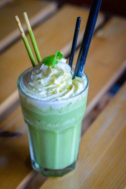 çırpılmış krem nane yaprakları çikolata sopa ile harmanlanmış matcha latte