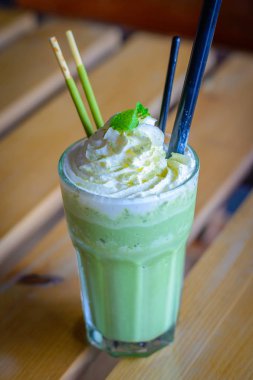 çırpılmış krem nane yaprakları çikolata sopa ile harmanlanmış matcha latte
