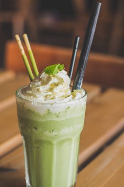 çırpılmış krem nane yaprakları çikolata sopa ile harmanlanmış matcha latte