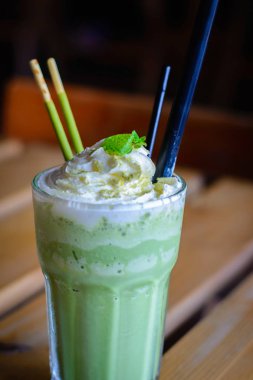 çırpılmış krem nane yaprakları çikolata sopa ile harmanlanmış matcha latte