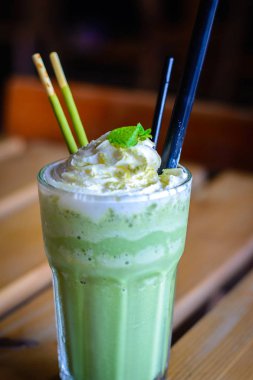 çırpılmış krem nane yaprakları çikolata sopa ile harmanlanmış matcha latte