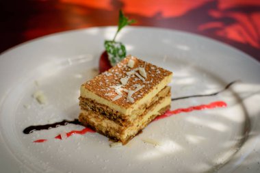 Tiramisu tatlı badem ile. çilek, çikolata sosu ve çilek sosu