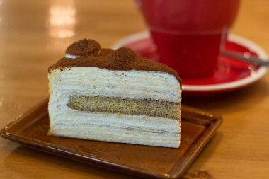 bir sürahi kahve ile küçük bir tabakta Mille krep pasta