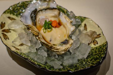 Rock istiridye, ponzu sos, somon karaca, buz bir yatak üzerinde taze soğan