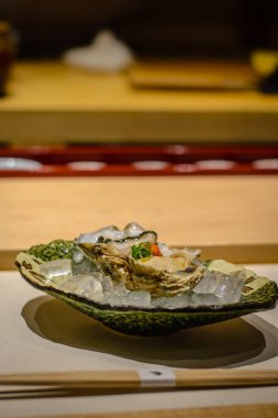 Rock istiridye, ponzu sos, somon karaca, buz bir yatak üzerinde taze soğan