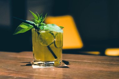 kokteyl limon dilimleri ve yaprakları bir cam ile