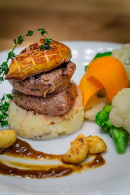 Izgara Bonfile fileto mignon madalyon pastırma ile patates ve mevsimlik Sebze püresi. Kaz ciğeri ile tepesinde ve kırmızı şarap sarımsak confit sos ile.