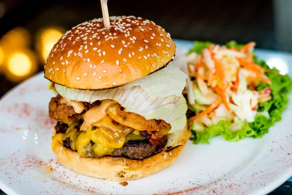 Sığır patty Teksaslı Burger, tatlı turşu, kızarmış soğan, ızgara akçaağaç pastırma, kaşar peyniri, ızgara ve Teksaslı Barbekü olabilir