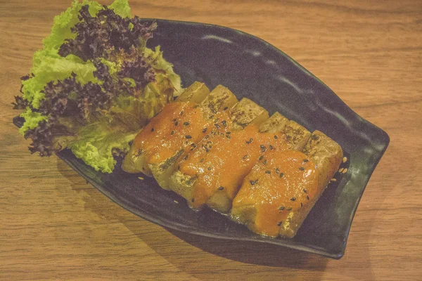 grilled japanese taro yam cake with black sesame seeds and lettuce