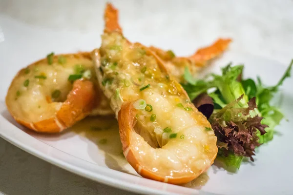 Tavada Avustralya ıstakozunu tuzlu sos ve taze soğan ve marul ile karıştırın