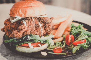 Şef oluşturma kızarmış tavuk, marul, domates, monterey peyniri, zeytinyağı vinagrette ve patates kızartması ile karışık salata ile ızgara börek burger