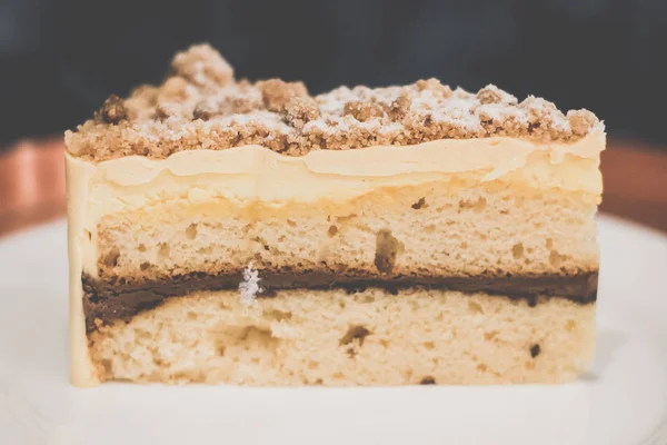 Jaffa-Kuchen Vanille-Pfund-Kuchen zwischen reichhaltigem Schokoladenmousse, Orangenmarmelade und Mousse.ine eingeklemmt, garniert mit Mandelbutter-Crumble — Stockfoto