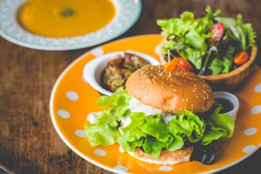 Ev yapımı tofu burger dikkatle tofu ve soğan teriyaki sos.küçük tavada kızarmış patates ve küçük salata ve kabak çorbası yapılmış