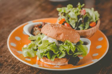 Teriyaki soslu tofu ve soğandan yapılmış ev yapımı burger. küçük tavada kızarmış rendelenmiş patates ve küçük salata ile