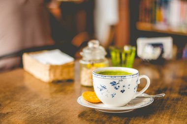 kahverengi şeker ve tarafında bir bardak su ile bir çin fincan yeşil çay matcha soya latte
