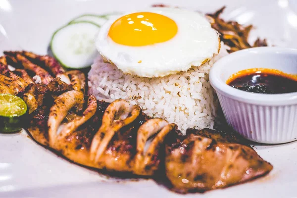 Nasi lemak Kokosrijst met gegrilde Argentijnse koning inktvis en zonnige kant omhoog ei, pinda's, ansjovis, komkommer, sambal Chilli — Stockfoto