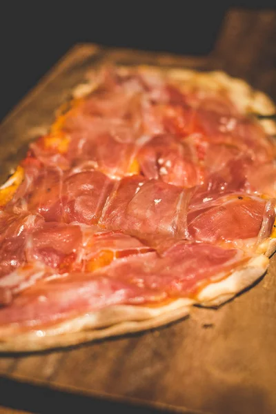 Pieczone focaccia di Recco z Parma Ham służył na drewnianej płycie — Zdjęcie stockowe