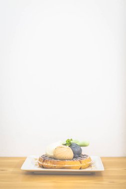 Waffle üzerinde Triple Scoop Dondurma ile ve beyaz çin plaka üzerinde akçaağaç şurubu ile servis