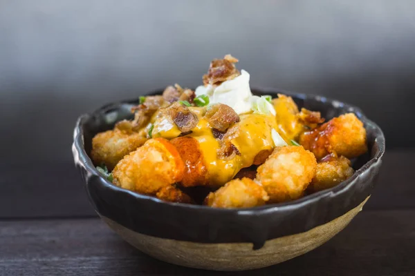 Gevrek tater tots acımasızca baharatlı jalapeno peynir sosu, akçaağaç sırlı pastırma ve ekşi krema içinde ıslatılmış. Acı sos bir sıçrama ile bitmiş