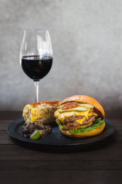 Amerikan burgeri. Bir çift wagyu yağ ve chuck karışımı börek topuzuniçinde börek ve pastırma ketçap karışımı. Meksika mısırve sote kekik mantar ile servis.