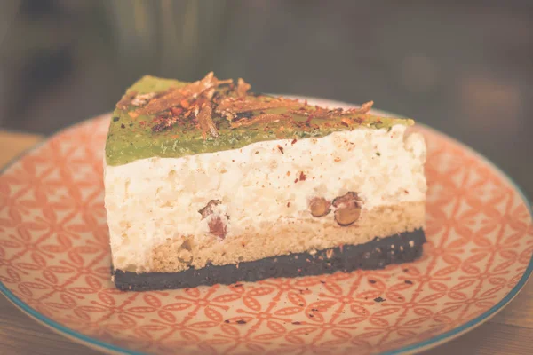 nasi lemak (southeast asian coconut rice) cheesecake served in a colourful small plate