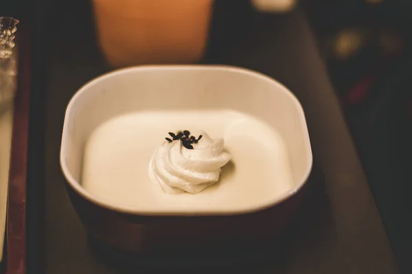 Comida de clase económica de vuelos aéreos servida en una bandeja con crema de vainilla con una cucharada de crema en la parte superior con jugo de naranja en el fondo —  Fotos de Stock