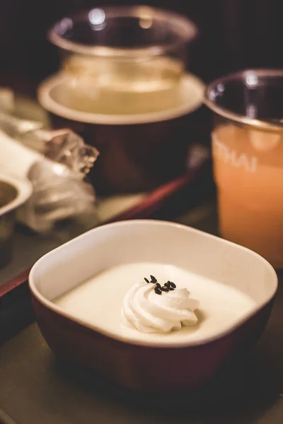 Comida de clase económica de vuelos aéreos servida en una bandeja con crema de vainilla con una cucharada de crema en la parte superior con jugo de naranja en el fondo —  Fotos de Stock