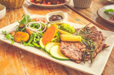 Prime Ribeye Steak 250 gram ızgara prime ribeye biftek roket patates salatası ve karışık sote sebze, biber sosu ile servis