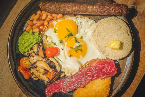 Good Ol\' English Fry up Garlic and herb beef sausage with baked beans, beef bacon, cherry tomatoes, eggs, hash brown, mushy peas, mushrooms and toast