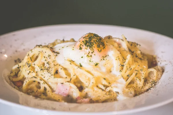 cheeszy smoked duck spaghetti pasta in white carbonara sauce topped with sous vide egg and herb