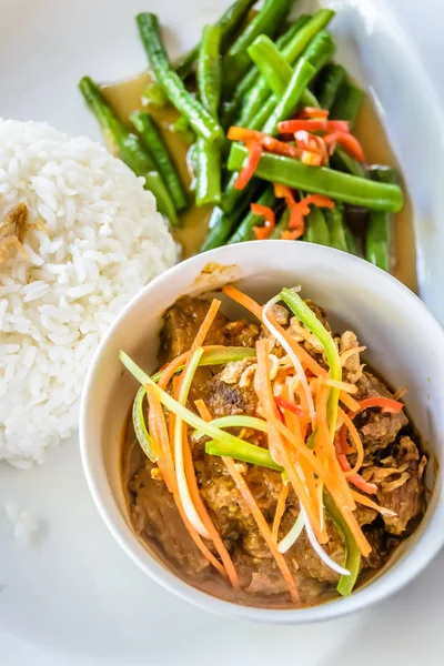 Carne rendang servido com cenouras julienned em cima, feijão francês frito e arroz branco — Fotografia de Stock