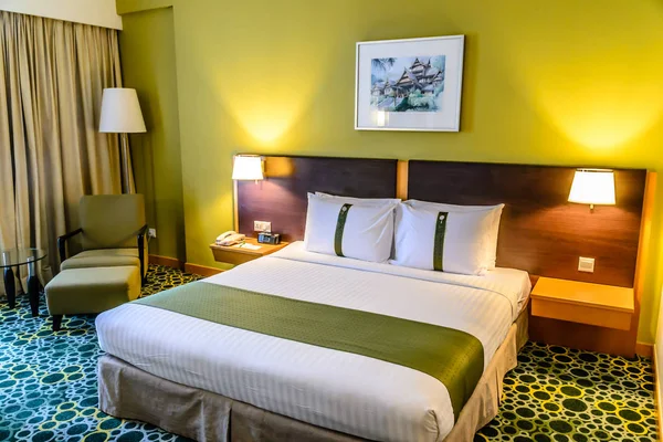 Dormitorio beautifuyl con cama doble, almohadas, mesas auxiliares, lámparas, pintura y despertador —  Fotos de Stock
