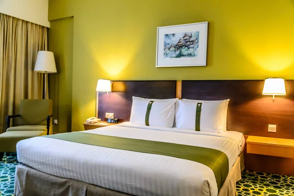 Dormitorio beautifuyl con cama doble, almohadas, mesas auxiliares, lámparas, pintura y despertador —  Fotos de Stock