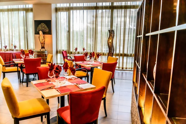 Kolorowe stoły i krzesła w restauracji z otwartą kuchnią — Zdjęcie stockowe
