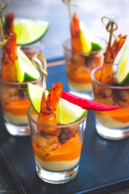 Kreol soslu karides şişi ve krem peynir sosu ve limon dilimi shot bardağında servis edilir.