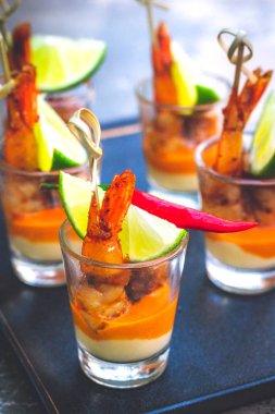 Kreol soslu karides şişi ve krem peynir sosu ve limon dilimi shot bardağında servis edilir.