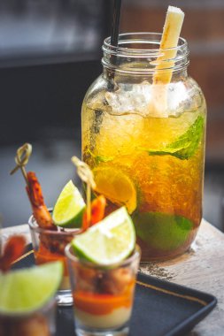 Büyük bardakta ve karides şişte servis edilen limon, nane ve siyah şekerli klasik Küba mojito 'su.