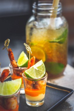 Büyük bardakta ve karides şişte servis edilen limon, nane ve siyah şekerli klasik Küba mojito 'su.