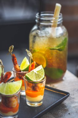 Büyük bardakta ve karides şişte servis edilen limon, nane ve siyah şekerli klasik Küba mojito 'su.