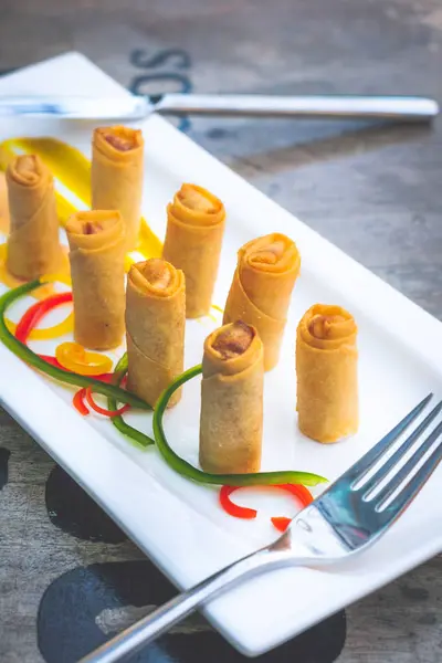 Krabbenfrühlingsrollen halbiert und auf einem weißen Porzellanteller serviert — Stockfoto