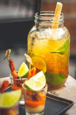 Büyük bardakta ve karides şişte servis edilen limon, nane ve siyah şekerli klasik Küba mojito 'su.