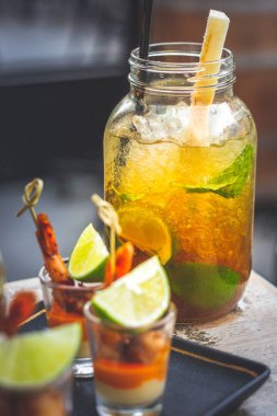 Büyük bardakta ve karides şişte servis edilen limon, nane ve siyah şekerli klasik Küba mojito 'su.