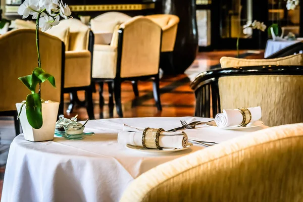 Beautiful restaurant with white linen table cloths, white linen napkins and mother of pearl napkin holders — Stock Photo, Image