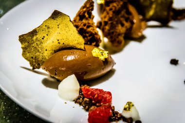 Çikolatalı ganache. Çikolatalı dondurma. Yenebilir altın, ahududu ve köpüklü.